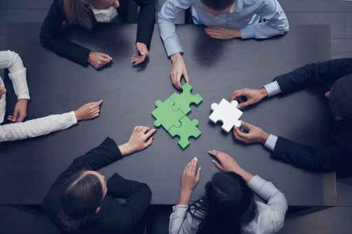 Business people assembling puzzle